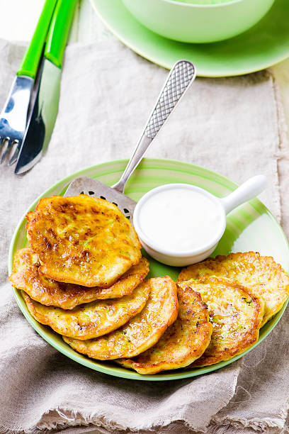 istock vegetable marrows fritters with sour cream on a green plate. 517610890