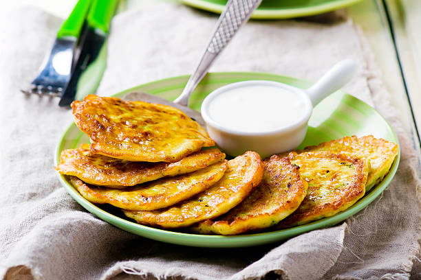 istock vegetable marrows fritters with sour cream on a green plate. 517610910