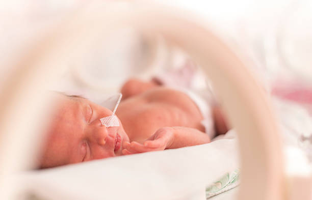Premature newborn  baby girl Premature newborn  baby girl in the hospital incubator after c-section in 33 week premature stock pictures, royalty-free photos & images