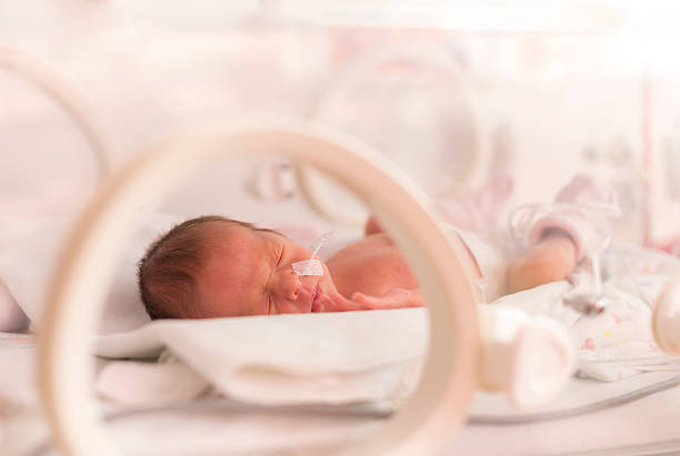 Premature newborn  baby girl Premature newborn  baby girl in the hospital incubator after c-section in 33 week premature stock pictures, royalty-free photos & images