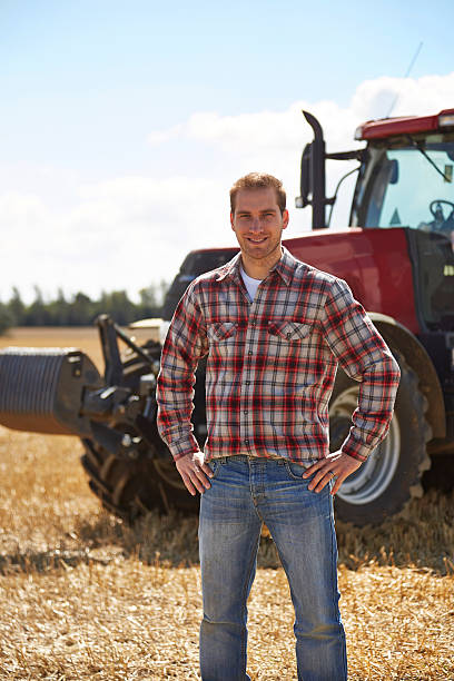 istock Proud farmer standing in front of tractor 517617891