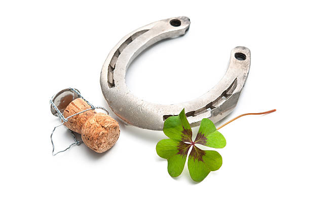 istock Horseshoe and champagne cork with a four leaf clover 517621605
