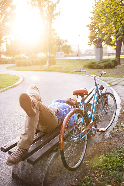 istock Young man laying on bench and enjoying nice weather 517629198