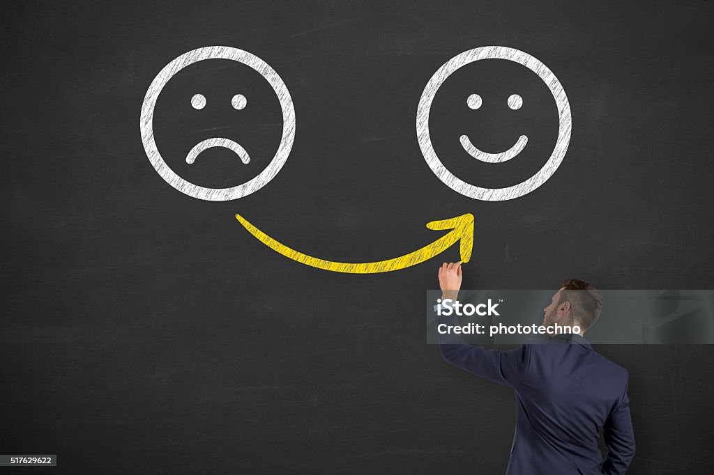 Main tirage au sort malheureux et heureux de Smileys sur Tableau noir - Photo de Client libre de droits