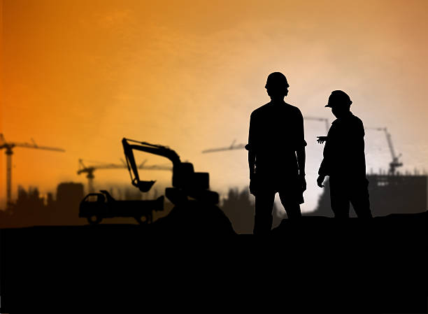 istock silhouette engineer looking Loaders and trucks in a building sit 517631400