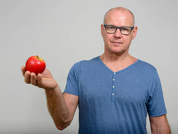 istock Senior man holding apple 517632062