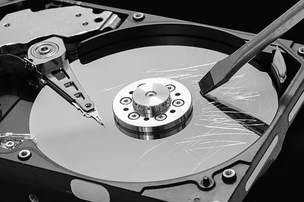 istock Screwdriver destroying hard disk drive platter to erase the data 517632568
