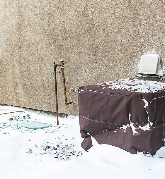 istock Residential air conditioning unit wrapped with protective cover in blizzard 517632860