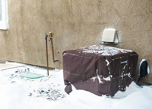 istock Residential air conditioning unit wrapped with protective cover in blizzard 517632954