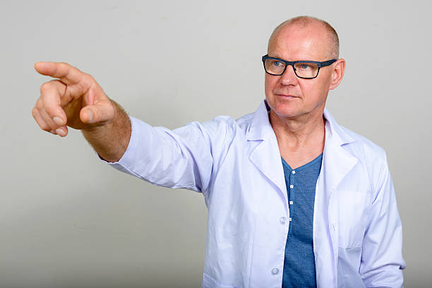 istock Mature man doctor pointing finger 517633504