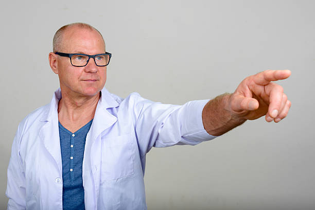 istock Mature man doctor pointing finger 517633524