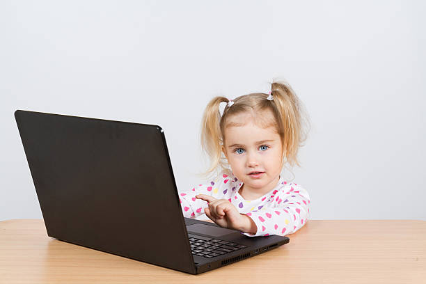 istock little girl at the computer. 517634514
