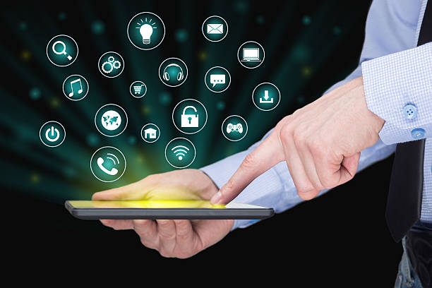 istock Businessman holding a tablet pc with mobile applications icons on 517635862