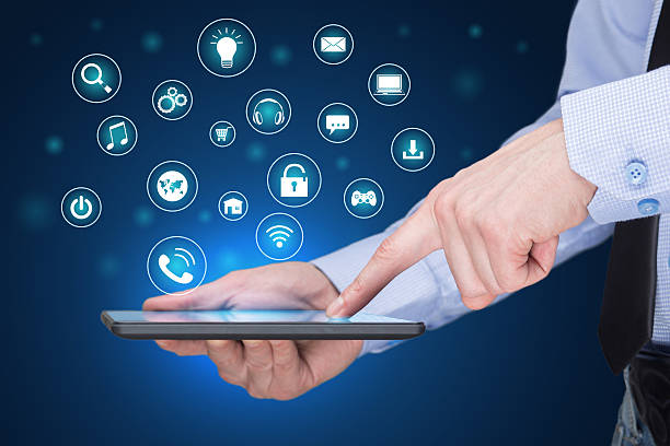 istock Businessman holding a tablet pc with mobile applications icons on 517635938