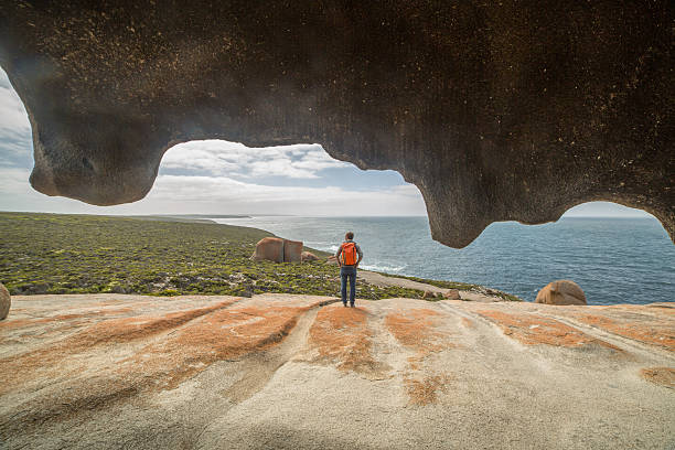 Cheerful young man at The Remarkable rocks, located in Flinder's  chase National park on Kangaroo Island, SA, Australia.