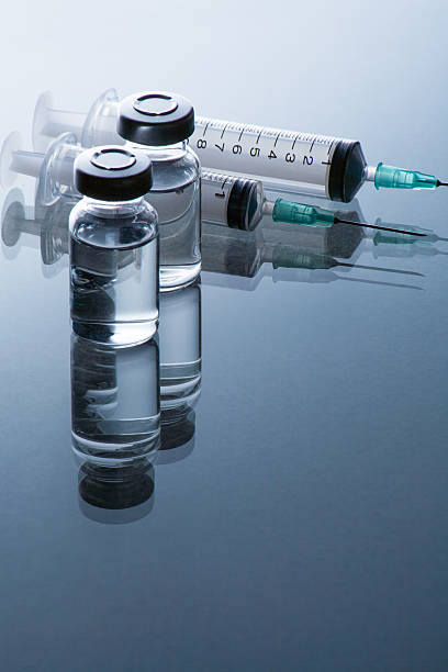istock medical ampoules and syringe on blue background 517638763