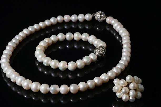 istock pearl necklace, bracelet and finger ring on black background 517638963
