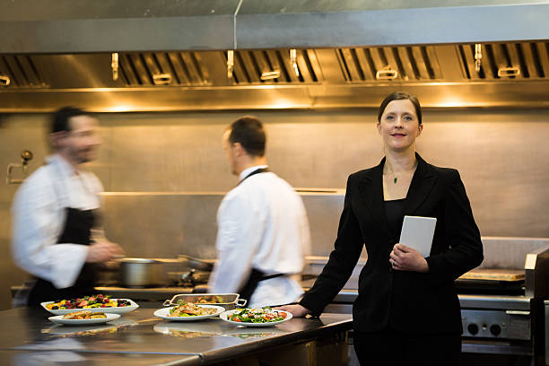 gerente de restaurante en una cocina comercial - azafata fotografías e imágenes de stock