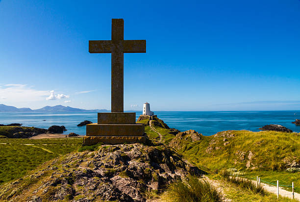 istock Cross and lighthouse on Llanddwyn Island, Anglesey 517639326