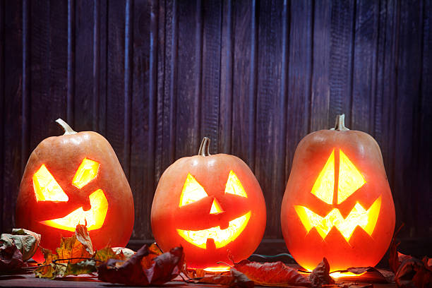 istock Jack o lanterns  Halloween pumpkin face on wooden background 517639395