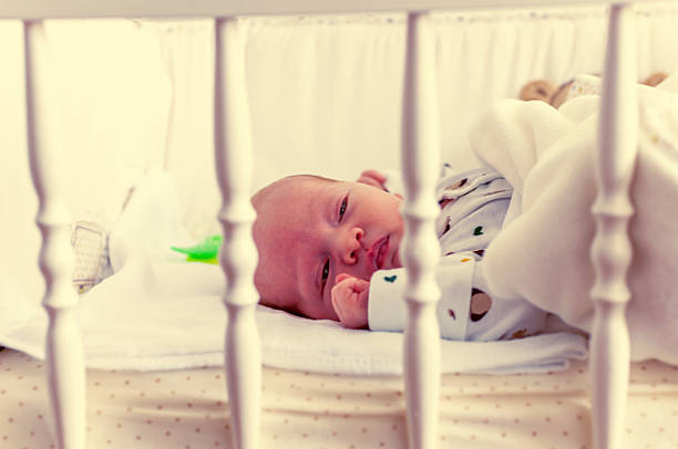 istock Newborn baby in crib 517640875