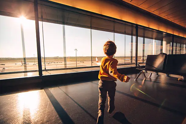 Young boy is having fun in an airport lounge while waiting for a flight 