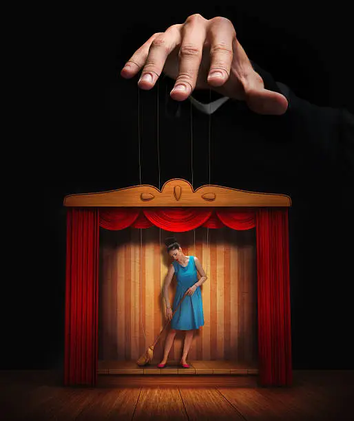 Male hand controlling a small woman puppet