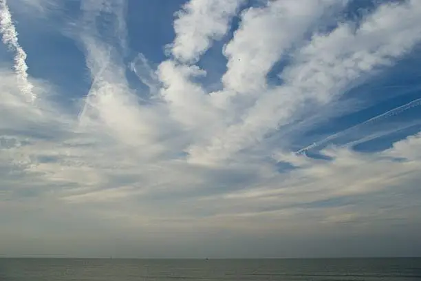 clouds on blue sky in form of stripes at north sea coast
