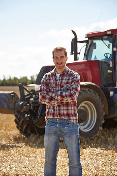 istock Proud farmer standing in front of tractor 517642853