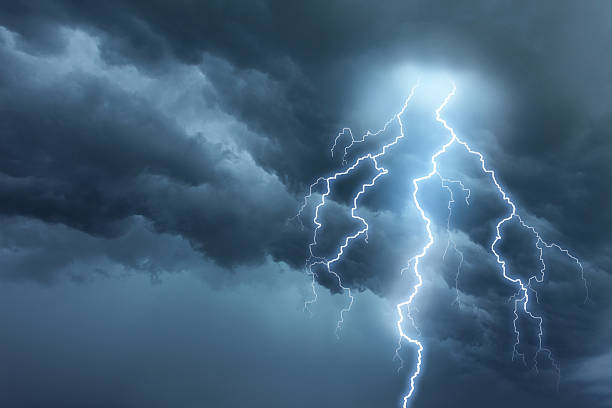 Thunderstorm lightning with dark cloudy sky Bright lightning illuminates dark cloudy sky during a thunderstorm. Natural dangers and majestic beauty. Real cloudscape with computer generated lightning. Copy space on image side. storm cloud stock pictures, royalty-free photos & images
