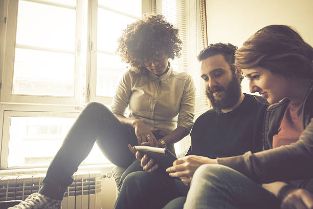 istock Young friends consulting a digital tablet 517643499