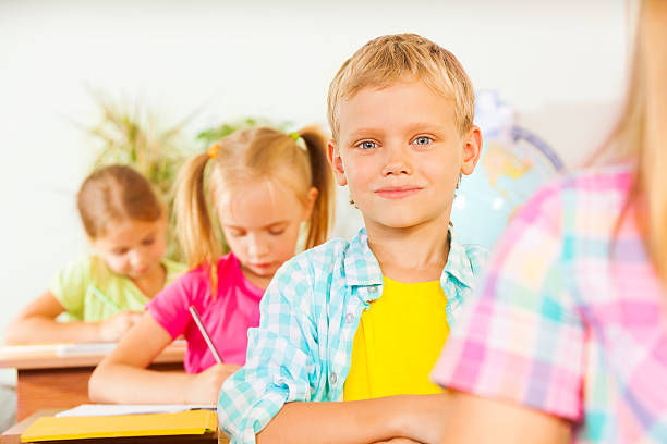 istock Boy's portrait in classroom with other pupils 517644065