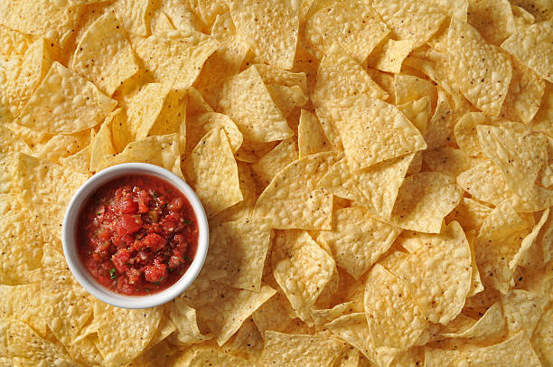 Chips and Salsa Detail studio image of yellow corn tortilla chips and fresh salsa. tortilla chip photos stock pictures, royalty-free photos & images