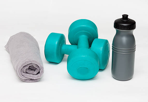 istock Blue bumbbells with gray bottle and towel on white 517653150