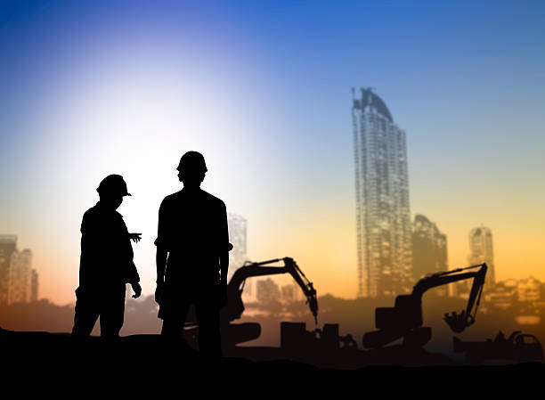 istock silhouette engineer looking Loaders and trucks in a building sit 517654292