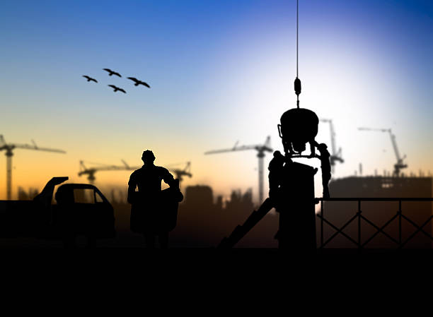 istock silhouette engineer looking at blueprints in a building site ove 517655108