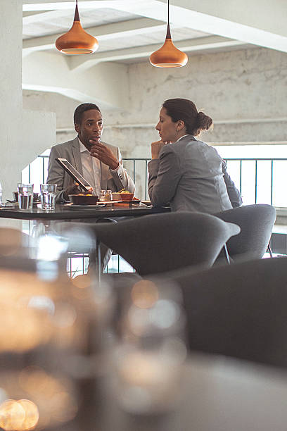 仕事一色と若い男性が、ビジネスラウンジでレストラ��ン - two people business lunch multi ethnic group meeting ストックフォトと画像