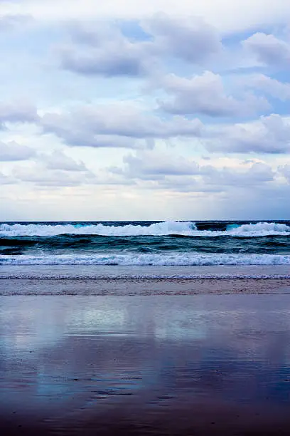 Portrait of the sea crashing onto the shore. Against the horizon.