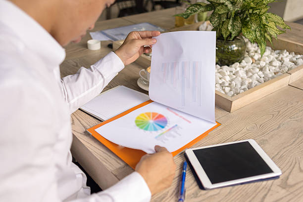 el hombre mirando en el pastel de carne colorido gráfico de documento - spreadsheet pie chart chart report fotografías e imágenes de stock