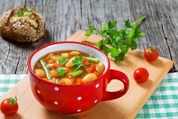 istock Minestrone vegetable soup with beans, cauliflower, tomatoes, close-up, top view 517661804