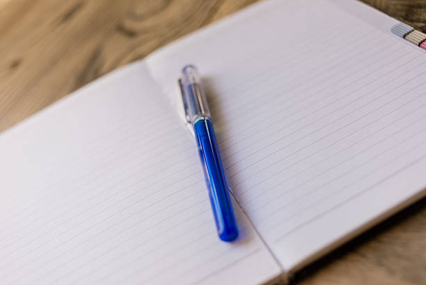 istock Close up of the blue pen on the opened notebook 517662366