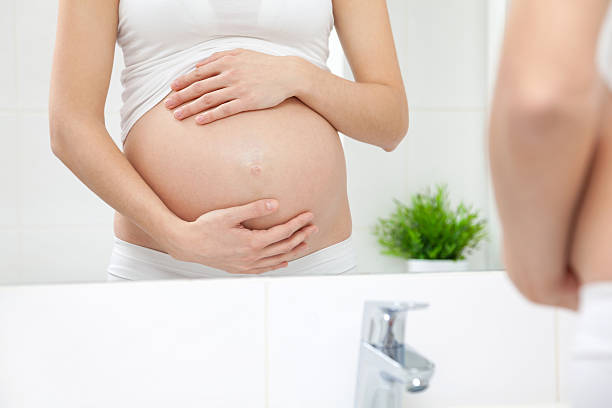 istock Pregnant woman in bathroom mirror 517663220