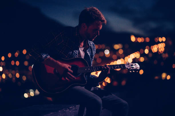 istock Young man plays guitar for the city 517663454