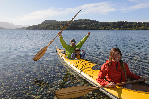 Family enjoying the holidays in the lakes of Patagonia, together with sea kayaking.