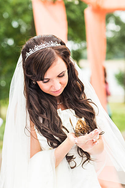 istock Bride hands holding a small butterfly outdoors 517664674