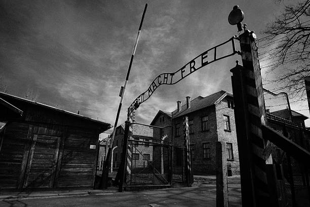 Auschwitz main gate Auschwitz, Poland - March 28, 2008: Main gate of Auschwitz-Birkenau (Auschwitz I) concentration camp in Poland, where 1.1 million people where killed (90% Jews) by the Nazi army during the World War II (1940-1945). The Soviet troop liverated the camp on January 27 in 1945. In the following decades it became a symbol of the Holocaust. In 1947, Poland founded a museum on the site of Auschwitz I and II, and in 1979 it was named a UNESCO World Heritage Site. fascism photos stock pictures, royalty-free photos & images