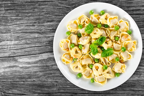istock tortellini with green peas, fried Pine nuts,  top view 517667582