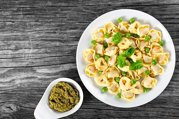 istock tortellini with green peas, fried Pine nuts,  top view 517667648