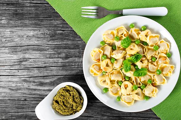 istock tortellini with green peas, fried Pine nuts,  top view 517667712