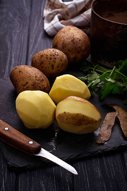 istock Uncooked peeled potatoes on dark background 517667744